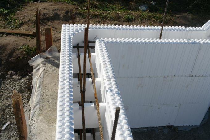 In the photo - a permanent formwork for walls teeth. polystyrene plates stacked thanks cloves in a flat wall.